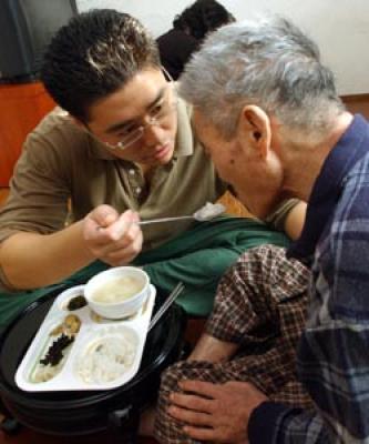 치매노인에게 손자가 씹기 편한 음식을 대접하고 있다.  ⓒ2007 welfarenews