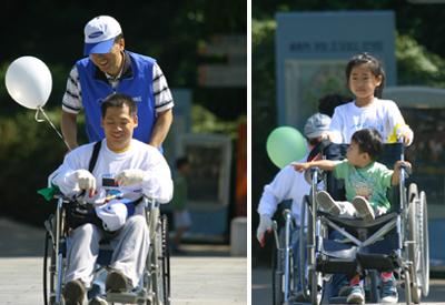 참가자들이 휠체어를 타고 또 뒤에서 밀면서 즐겁게 장애체험을 하고 있다.  ⓒ2007 welfarenews