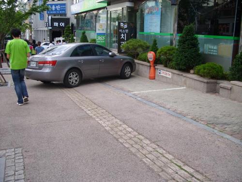 서울강남구 학동 농협, 고객전용주차장을 보도에 설치하여 시각장애인을 위한 유도시설위에 고객의 차량을 주차토록 하고 있어 개선이 요구된다. ⓒ2009 welfarenews