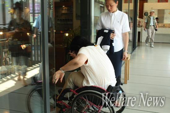 일본 장애인 아라이 쯔네미씨가 휠체어를 타고 인사동 쌈지길 가게 안을 들어가기 위해 힘겹게 턱을 넘고 있다.
 ⓒ2010 welfarenews