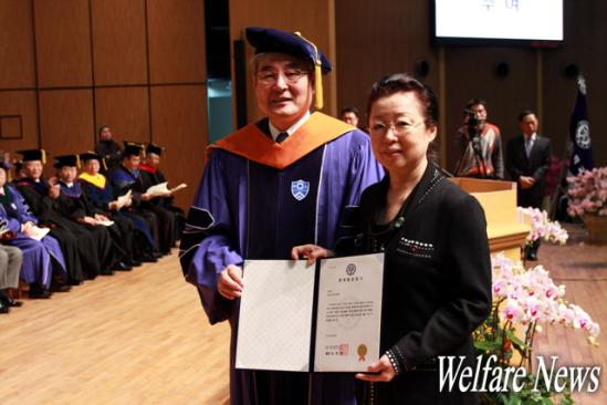 신형진 씨의 어머니 이원옥(오른쪽) 씨가 연세대학교 김한중 총장(왼쪽)으로부터 명예졸업증서를 수여 받은 후 기념사진을 촬영하고 있다. ⓒ2011 welfarenews