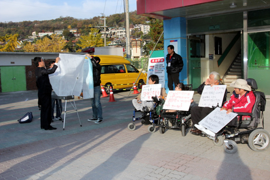▲ 성북구 성북동 제2투표소에서 장애여성 이라나 씨가 '장애인의 참정권을 보장해 달라'며 시위를 벌였다. 이에 선관위 측은 시위 6시간여 만에 1층에 임시 투표소를 설치했다.
