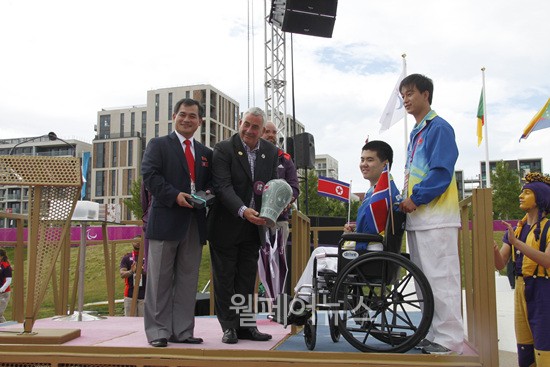 ▲ 런던장애인올림픽선수촌에서 열린 북한선수단 입촌식에서 북한의 유일한 참가선수인 림주성(수영,S6)가 기념품을 전달하고 있다. ⓒ대한장애인체육회