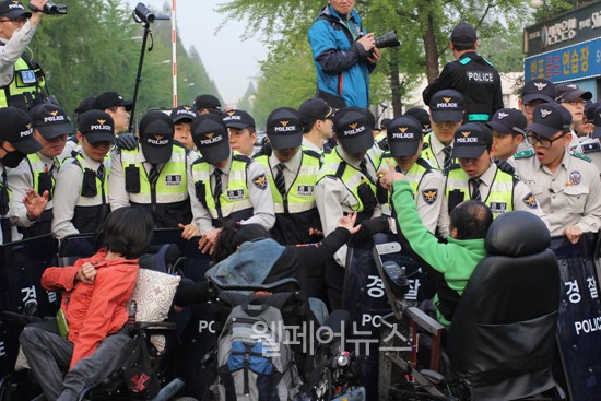 ▲ '시설보호'라는 명목 하에 입구를 봉쇄한 경찰과 충돌하는 장애계 활동가들.
