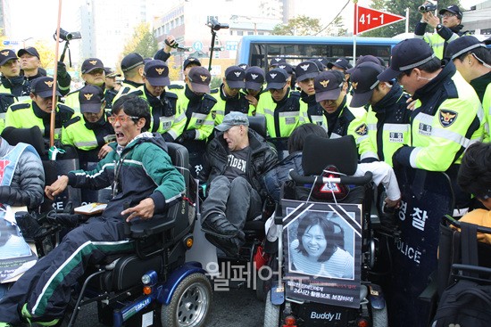 ▲ 故 김주영 활동가 장례식에 참석한 이들이 광화문광장에서 보건복지부로 향하는 도중 경찰들은 길을 가로막았고, 이에 항의하는 사람들을 채증했다.