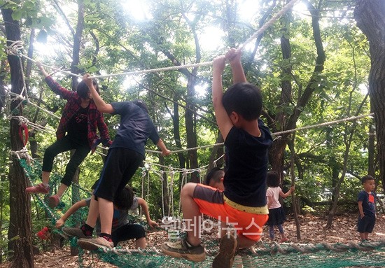 ▲ 광명 YMCA 어린이들이 직접 만든 숲속 놀이터에서 함께 놀고 있는 어린이들. ⓒ유니세프한국위원회