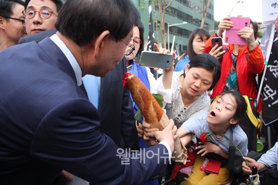 ▲ 최영은 활동가가 생존을 상징하는 빵을 박원순 시장에게 전달하고 있다.