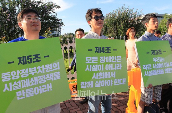 ▲ 기자회견 참가자들이 '수용시설 폐쇄선언' 손팻말을 들고 있다.
