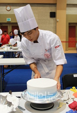 ▲ 소림학교 김재환 학생이 케이크에 데코레이션을 하고있다.