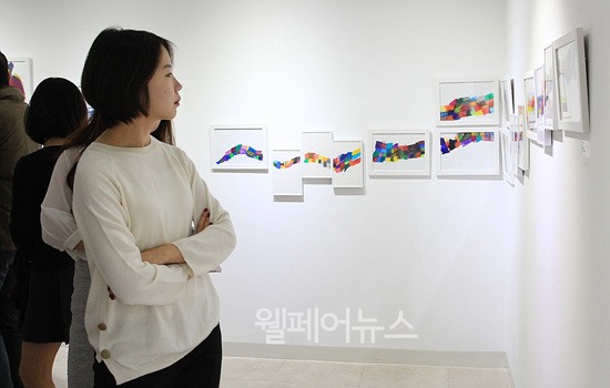 ▲ 관람객이 정경희 작가와 짝을 이룬 김건우 학생의 작품 '무지개 기차'를 관람하고 있다.