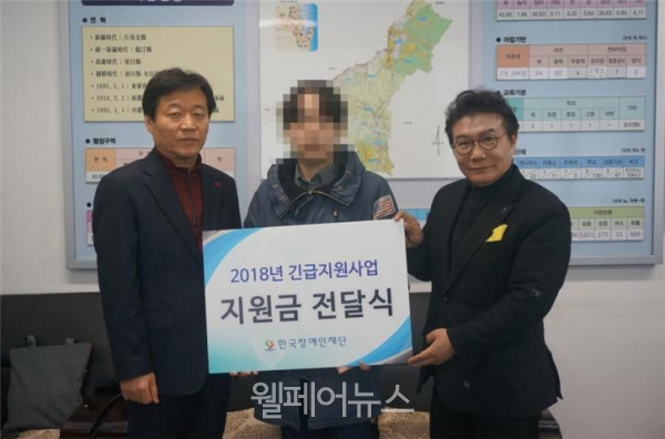 긴급지원금 13번째 수요자 김 씨(가운데)에게 긴급지원금을 전달한 한국장애인재단 이성규 이사장(오른쪽)과 동해면행정복지센터 박만수 면장(왼쪽). 사진제공/ 한국장애인재단