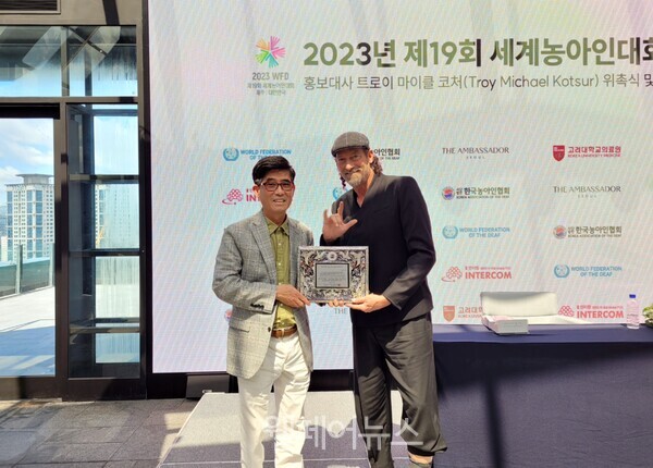 세계농아인대회 홍보대사로 나선 트로이 코처(오른쪽)가 한국농아인협회 변승일 회장과 기념사진을 촬영하고 있다.