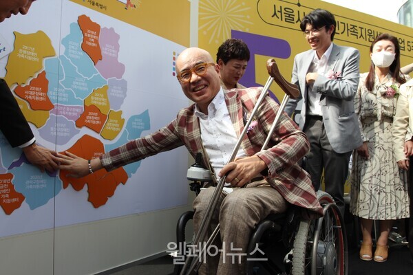 서울시 지도에 장애인가족지원센터가 위치한 곳을 대형퍼즐로 만들어 붙이는 모습. 서울시 박마루 명예시장이 퍼즐을 붙이며 웃음을 보이고 있다.