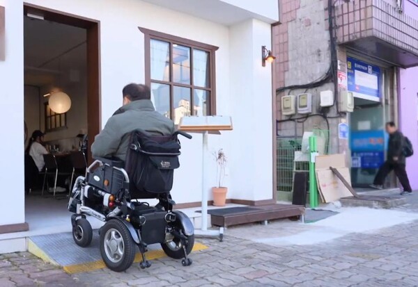 서울시 노원구의 소규모 음식점 입구에 설치된 경사로를 사용하고 있는 남성