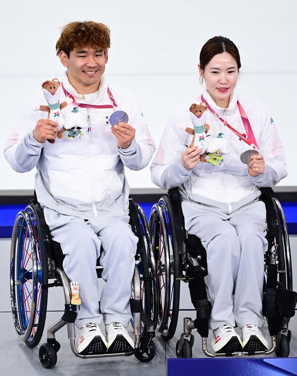 백혜진, 이용석 선수가 나란히 은메달을 들고 마스코트를 찾고 있다.