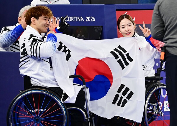 휠체어 컬링 백혜진선수와 이용석 선수가 택극기를 들고 웃고 있는 모습이다.